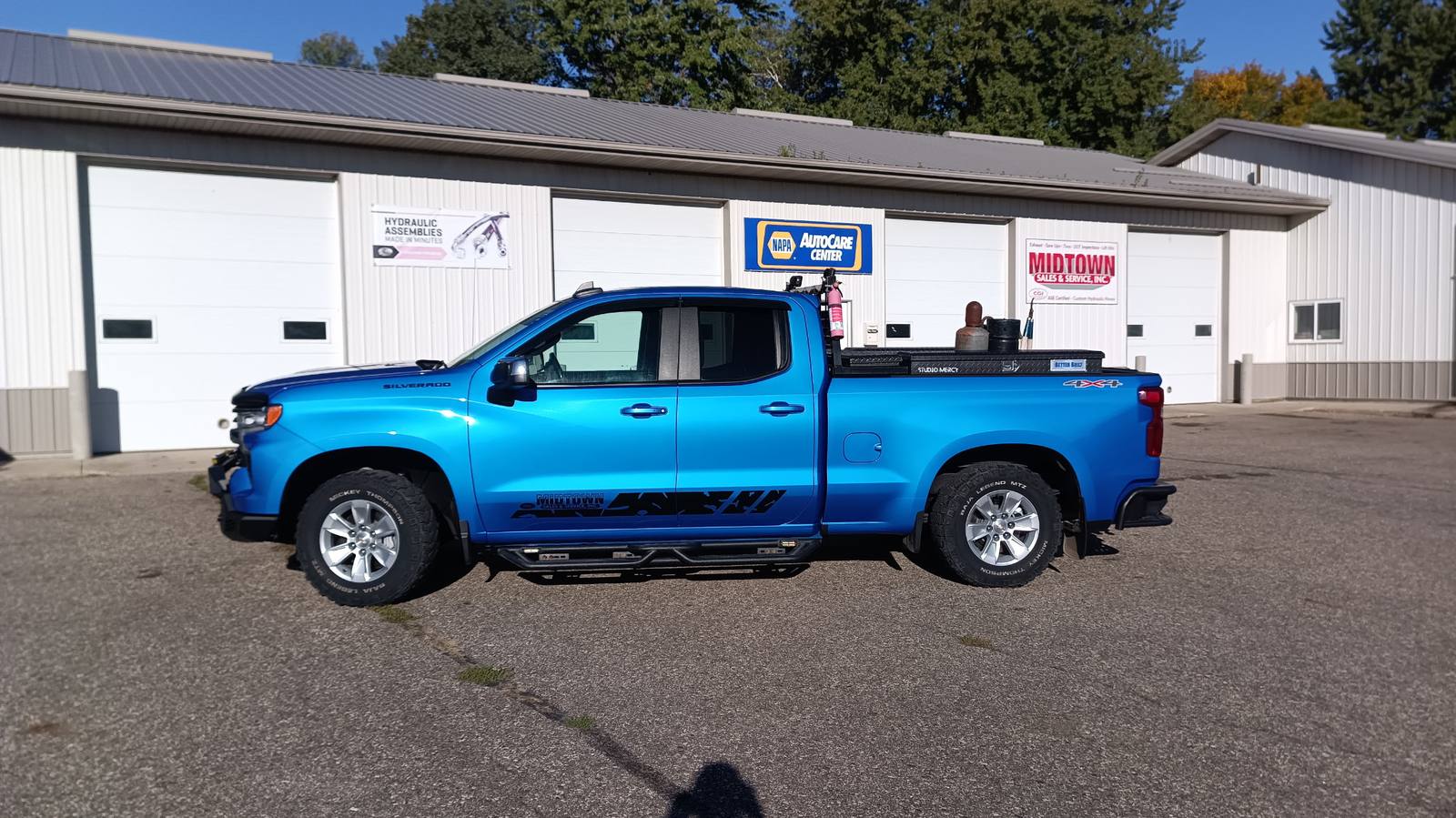 Blue Midtown Sales and Service Silverado service truck parked in front of the shop